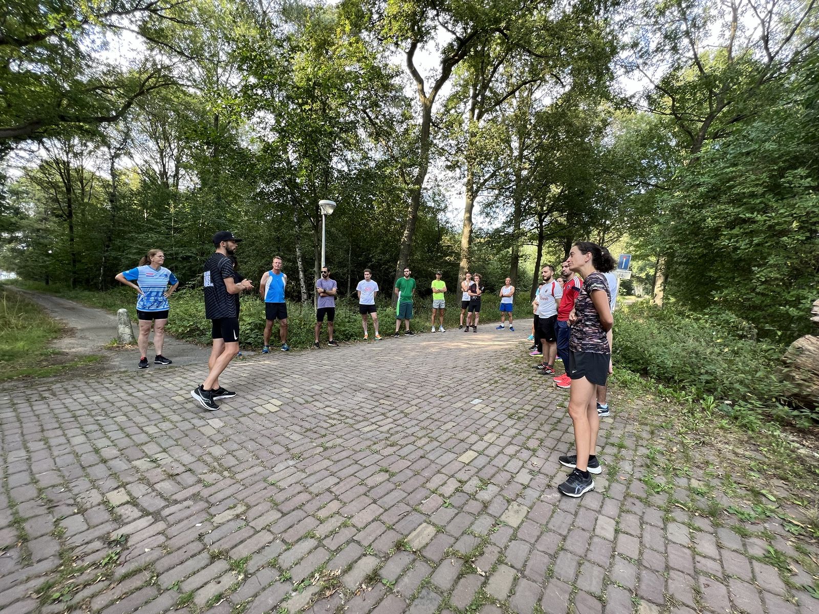 Groep lopers krijgt uitleg van een trainer voor de training